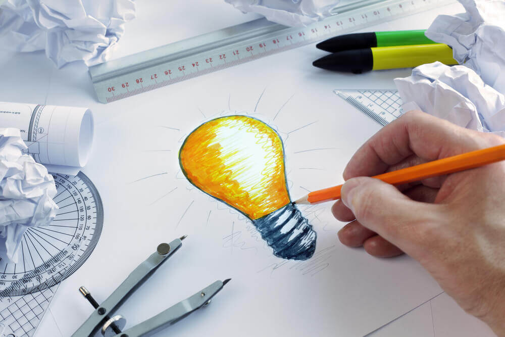 A drawing of a lightbulb on paper indicating anew bright idea